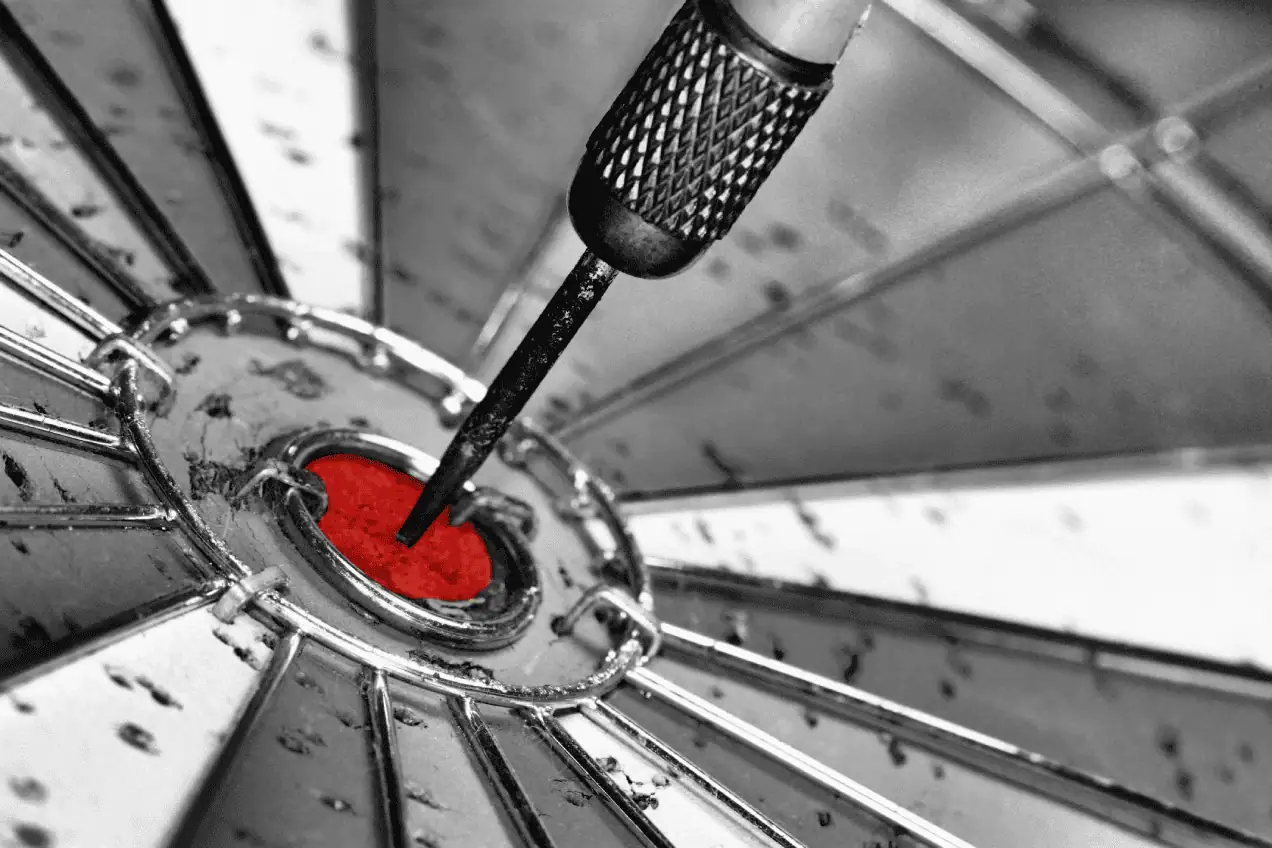 A dart striking the exact center of a dartboard bullseye